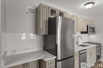 Chicago apartment for rent - A modern kitchen with a stainless steel refrigerator and a marble countertop.