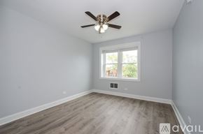 Chicago apartment for rent - A room with a ceiling fan and a window.
