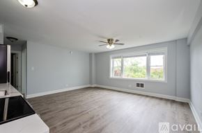 Chicago apartment for rent - A spacious room with a ceiling fan and a window overlooking a green area.