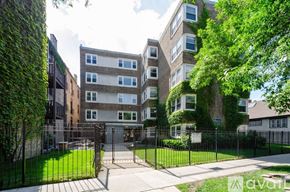 Chicago apartment for rent - A large building with a green hedge on the side.