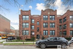 Chicago apartment for rent - A black car is parked in front of a red brick building.
