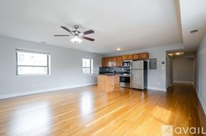 Chicago apartment for rent - A spacious kitchen with wooden floors and a ceiling fan.
