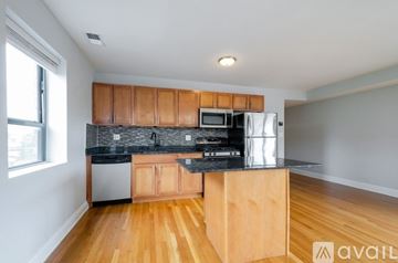 Chicago apartment for rent - A kitchen with wooden cabinets and a black countertop.