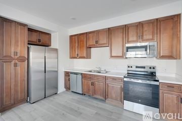 Hanford Ca apartment for rent - A kitchen with wooden cabinets and stainless steel appliances.