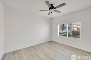 Hanford Ca apartment for rent - A room with a ceiling fan and a window overlooking a building.
