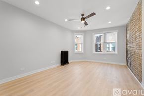 Chicago apartment for rent - A room with a ceiling fan and wooden flooring.