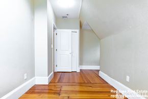 Boston apartment for rent - A hallway with a white door and wooden floors.