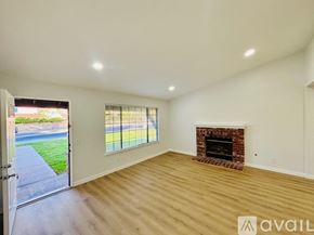 Lancaster house for rent - A room with a fireplace and a sliding glass door leading to a backyard.