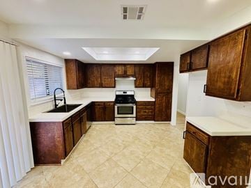 Lancaster house for rent - A kitchen with brown cabinets and a white countertop.