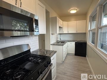 Philadelphia house for rent - A kitchen with a black stove top oven and white cabinets.