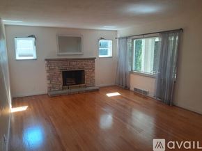 St. Louis house for rent - A living room with a fireplace and a television.
