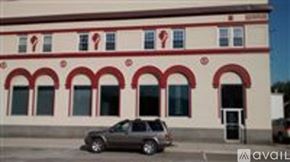 Vassar apartment for rent - A building with red arches and a car parked in front.