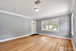 St. Petersburg townhouse for rent - A room with wooden flooring and a window with a view of a building outside.