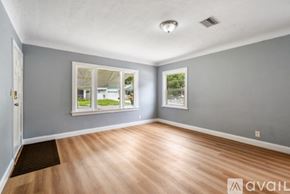 St. Petersburg townhouse for rent - A room with wooden flooring and two windows with pictures on the wall.