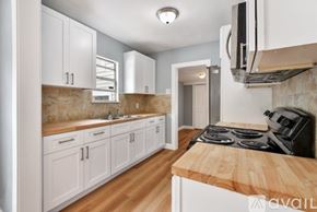 St. Petersburg townhouse for rent - A kitchen with white cabinets and a wooden countertop.