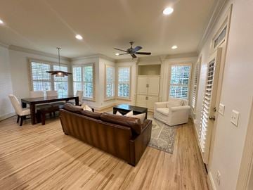 Greer house for rent - A living room with a brown couch and a ceiling fan.
