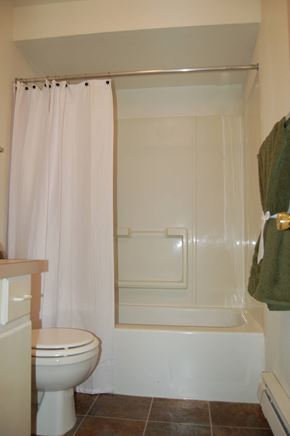 Federal Way apartment for rent - A white toilet sits next to a bathtub in a bathroom.