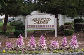 Federal Way apartment for rent - A sign for Laurelwood Gardens Apartment Homes is in front of a building.