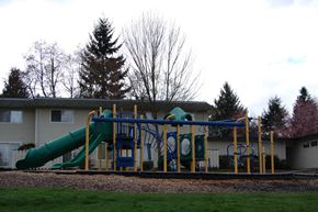 Federal Way apartment for rent - A playground with a green slide and a blue and yellow structure.