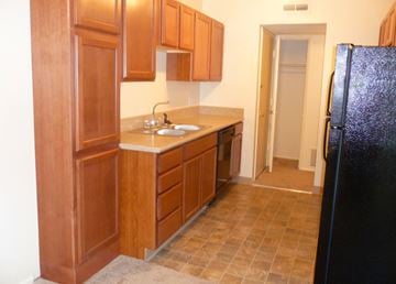 Bellevue apartment for rent - A kitchen with wooden cabinets and a black refrigerator.