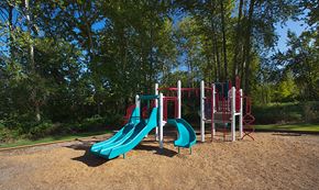 Burien apartment for rent - A playground with a red and blue slide and a red and white climbing frame.