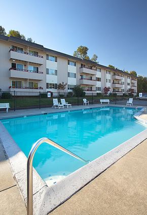 Burien apartment for rent - A swimming pool in front of apartment buildings.