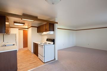 Burien apartment for rent - A kitchen with a white stove and wooden floors.