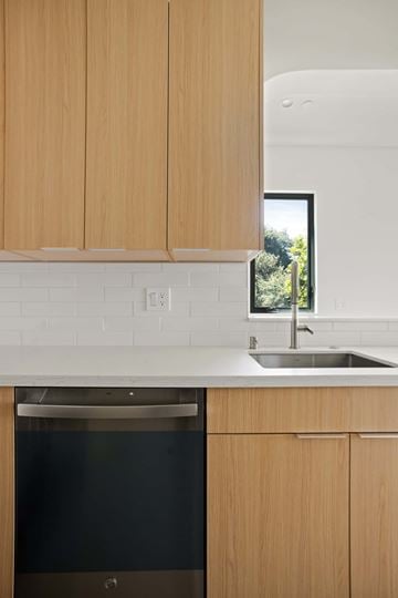 Los Angeles house for rent - A kitchen with wooden cabinets and a black dishwasher.