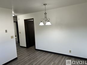 Pekin apartment for rent - A room with a wooden floor and a chandelier hanging from the ceiling.