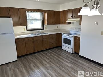 Pekin apartment for rent - A kitchen with wooden cabinets and a white refrigerator.