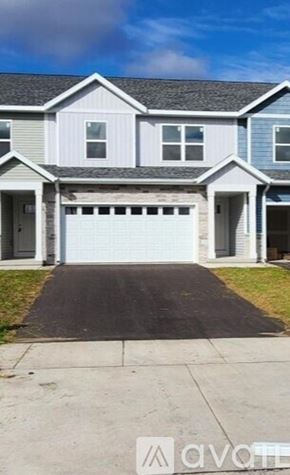 Weston house for rent - A two-story house with a garage door is for sale.
