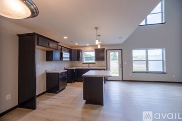 Weston house for rent - A spacious kitchen with dark wood cabinets and a large island.