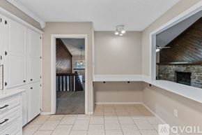 Maumelle house for rent - A room with a fireplace and a view of a dining area through an open door.