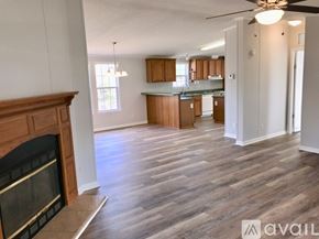 Denver house for rent - A living room with a fireplace and a kitchen in the background.