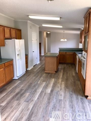 Denver house for rent - A kitchen with wooden cabinets and a white refrigerator.