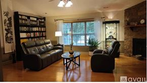 Boiling Springs house for rent - A living room with a black leather couch, a coffee table, and a fireplace.