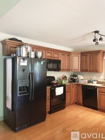 Boiling Springs house for rent - A black refrigerator stands in a kitchen with wooden cabinets.