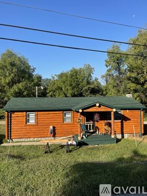 Somerset house for rent - A small wooden cabin with a green roof and a porch.