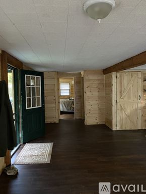Somerset house for rent - A room with wooden walls and a rug on the floor.