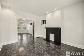 Cincinnati house for rent - A room with a fireplace and a window showing a garden outside.