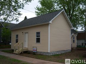 Eau Claire house for rent - A small house with a porch and a sign in front of it.