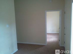 Eau Claire house for rent - A room with a carpeted floor and a doorway leading to another room.