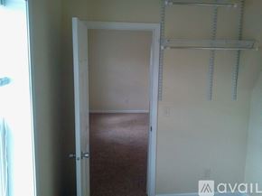 Eau Claire house for rent - A room with a carpeted floor and a door leading to another room.