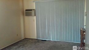 Berea apartment for rent - A room with a window covered by blinds and a wall-mounted air conditioner unit.
