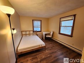 Quincy apartment for rent - A bedroom with a bed, chair, and window.