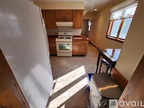 Quincy apartment for rent - A kitchen with a white refrigerator and wooden cabinets.