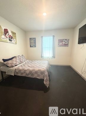 Davenport house for rent - A bedroom with a bed, a window with curtains, and a flat-screen TV mounted on the wall.
