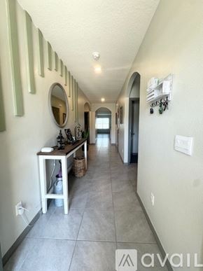 Davenport house for rent - A hallway with a mirror and a table with a basket underneath it.