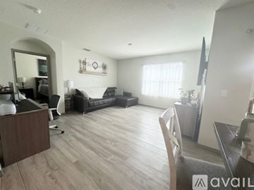Davenport house for rent - A living room with a black couch and a wooden floor.
