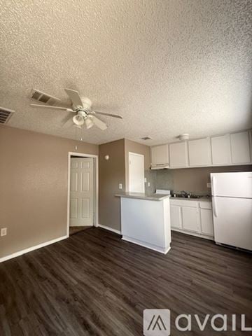 Bryan apartment for rent - A kitchen with white cabinets and a white fridge.